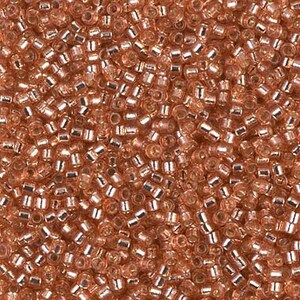 May include: A close-up view of a large quantity of small, round, copper-colored glass beads. The beads have a metallic sheen and are scattered randomly.