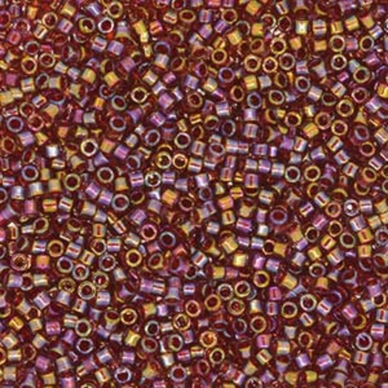 May include: A large quantity of small, round, iridescent seed beads in shades of red, gold, and purple.