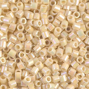 May include: A close-up view of a pile of small, opaque, off-white, square-shaped beads with a hole in the center. The beads have an iridescent finish.