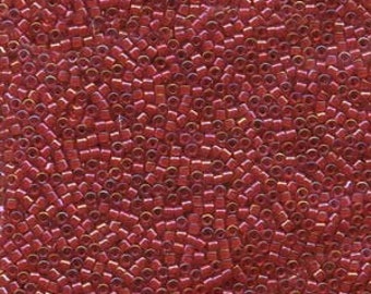 May include: A close-up view of a large quantity of small, red, iridescent glass seed beads.