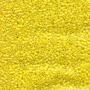 May include: A close-up view of a large quantity of small, bright yellow square seed beads.