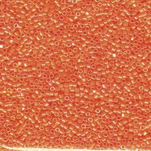 May include: A close-up view of a large quantity of small, orange, glass seed beads. The beads are uniform in size and shape, and they have a slightly iridescent finish.