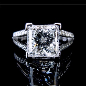 Könnte beinhalten: Ein Set aus drei Keramikbechern mit gesprenkelter, matter Oberfläche. Die Becher sind in Creme-, Hellgrau- und Dunkelgrautönen gehalten. Jeder Becher hat ein schlichtes, minimalistisches Design.