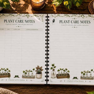 An open spiral-bound notebook showing two pages titled "Plant Care Notes" with columns for plant name, date, topic, and observations, surrounded by plants and a candle.