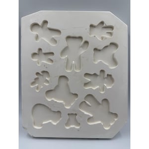 May include: A rectangular, off-white mold with various bear-shaped cavities. The mold features different bear designs, including standing, sitting, and lying down poses. The cavities are recessed, ready for filling with a suitable material.