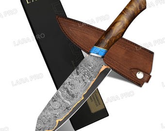 May include: A handmade Damascus steel knife with a wooden handle and a leather sheath. The blade has a unique pattern, and the handle is a light brown color. The knife is presented with a black box.