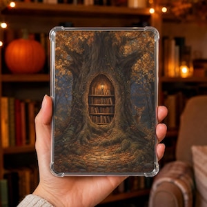 Puede incluir: Una funda protectora transparente rectangular para tableta o lector electrónico con la ilustración de un gran árbol con un tronco hueco que contiene una estantería iluminada por un pequeño farol, con hojas de otoño y un ciervo en el bosque.