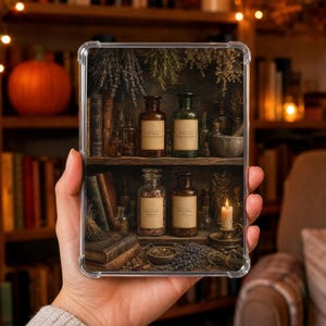 Op de afbeelding: Een doorzichtig telefoonhoesje met een print van twee houten planken vol apothekersflessen, gedroogde kruiden, oude boeken en een brandende kaars. De etiketten op de flessen bevatten tekst en de afbeelding toont een donkere, rustieke setting.