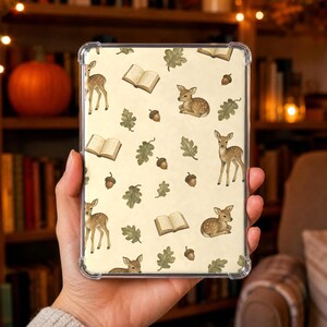 Op de afbeelding: Een doorzichtige tablethoes met een herhalend patroon op een crèmekleurige achtergrond. Het ontwerp bevat illustraties van bruine reekalfjes, open boeken, groene eikenbladeren en bruine eikels verspreid over het oppervlak van de hoes.