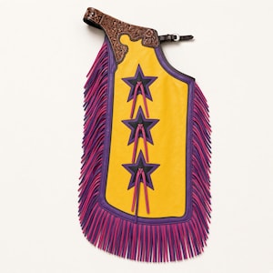 May include: A yellow leather chap featuring three black star cutouts with purple trim and pink leather fringe along the edges. The upper portion is made of brown tooled leather with a floral pattern and includes a buckle strap for fastening.
