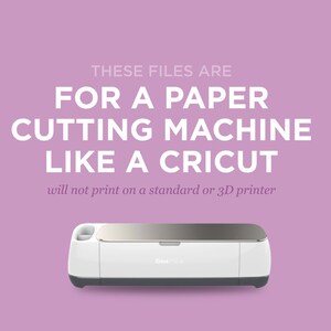 K&ouml;nnte beinhalten: Eine wei&szlig;e Cricut-Schneidemaschine mit silberner Oberseite und grauer Basis. Der Text "THESE FILES ARE FOR A PAPER CUTTING MACHINE LIKE A CRICUT" wird &uuml;ber der Maschine angezeigt. Der Text "will not print on a standard or 3D printer" wird unter der Maschine angezeigt.