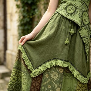 May include: A green patchwork skirt with a matching top. The skirt features a variety of patterns and textures, including floral and geometric designs. The skirt has a lace trim. The top has a sun design.