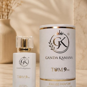May include: A white rectangular perfume bottle with a clear cap and a matching cylindrical white canister. Both feature a gold logo with the text GANDA KAMANA and TOM 9PM. The label indicates 100 ML and 3.38 FL. OZ. of Eau de Parfum.