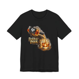 May include: Black t-shirt with a graphic of a bottle pouring whiskey into a glass with ice. The text "FEED the POUR" is in gold lettering. The bottle has a black label with a white "V" design.