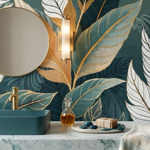 May include: A modern bathroom scene featuring a teal rectangular sink, gold faucet, and a round mirror. The backdrop is a wallpaper with large teal, gold, and white leaf patterns. A small glass bottle and soap dish are on the counter.