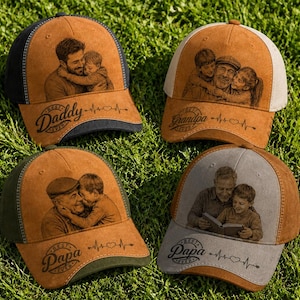 Op de afbeelding: Vier baseballpetten met suède-achtige voorpanelen voorzien van lasergegraveerde familiefoto's en tekst. De petten tonen de teksten Best Daddy Ever, Best Grandpa Ever en Best Papa Ever, vergezeld door hartjes en hartslaglijn-afbeeldingen.