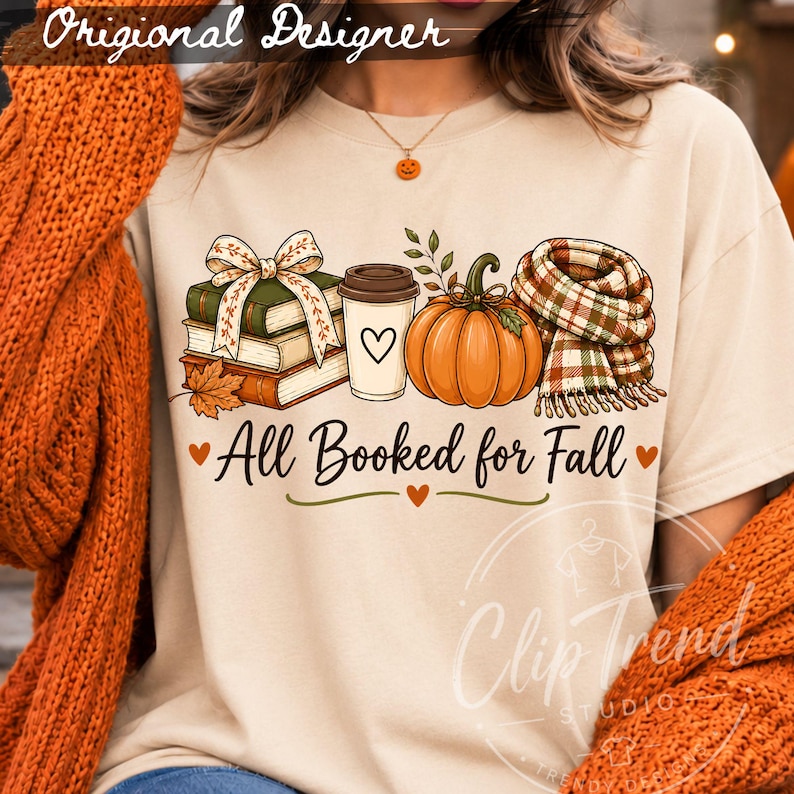 All Booked for Fall book lover design displayed on a cream T-shirt with books, pumpkin, coffee and plaid scarf in a Halloween fall setting.