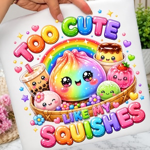 May include: A white fabric surface featuring a colourful graphic print of a rainbow-coloured dumpling, boba tea, pudding, and mochi in a woven basket. The text reads TOO CUTE LIKE MY SQUISHES in bright, bubbly, multi-coloured bubble letters.