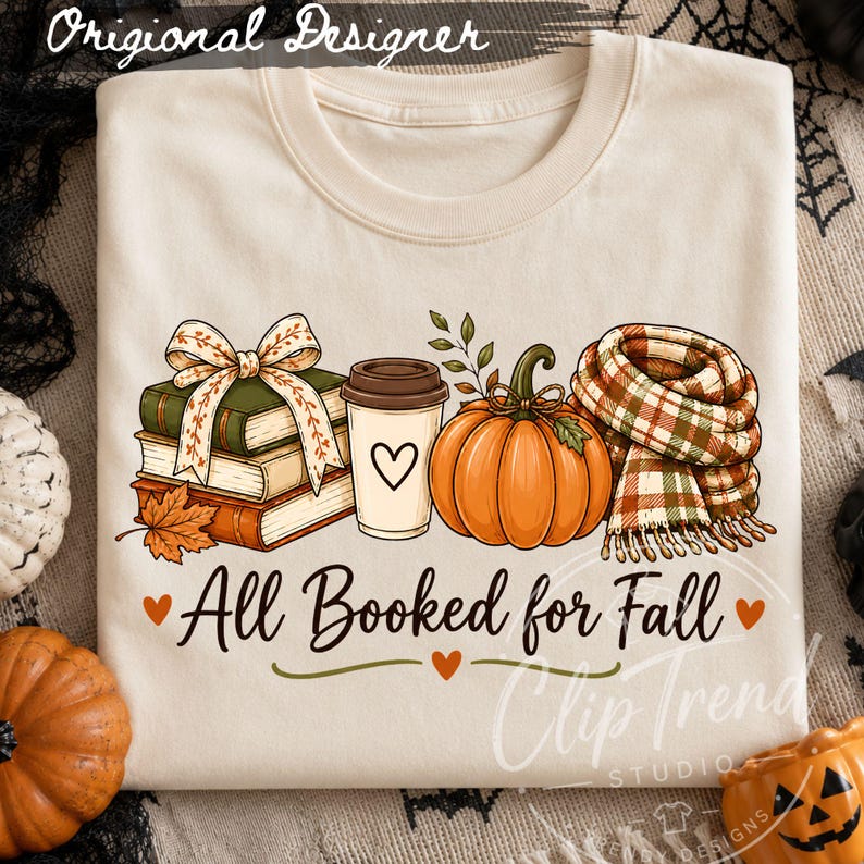 All Booked for Fall book lover design displayed on a cream T-shirt with books, pumpkin, coffee and plaid scarf in a Halloween fall setting.