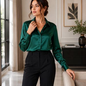 May include: A long-sleeved button-down shirt in a deep emerald green satin fabric with a classic collar and buttoned cuffs, paired with solid black tailored trousers featuring a high-waisted design and a clean, straight-leg silhouette.