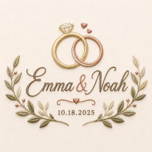 Peut inclure: Un motif de broderie représentant deux anneaux entrelacés, l'un doré et l'autre en or rose, au-dessus du texte Emma & Noah. Sous les prénoms se trouvent un petit cœur et la date 18.10.2025. L'ensemble est encadré par deux rameaux d'olivier.