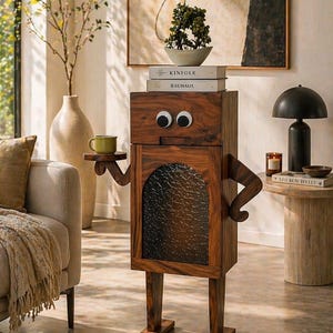 May include: A whimsical wooden cabinet with googly eyes, arms, and legs, holding a small green cup. The cabinet has a dark wood finish and a textured glass door. Books and a small plant sit on top, adding to the playful design.