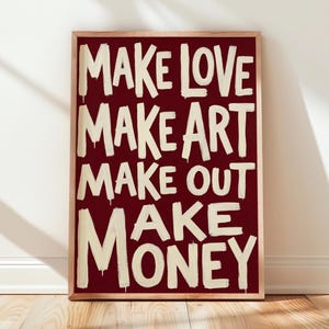 Poster con scritta "Make Love Art Out Money" e design tipografico, colore rosso bordeaux, ideale per decorare le pareti.