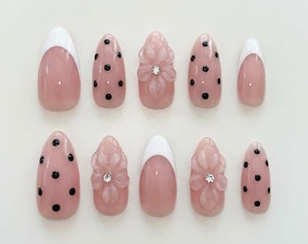 Uñas con manicura francesa rosa: lunares negros, cristales florales 3D, uñas de gel personalizadas.
