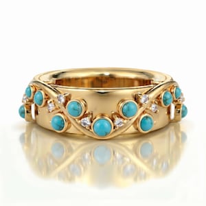 Puede incluir: Un anillo de banda de oro amarillo pulido que presenta una serie de piedras turquesa redondas de corte cabujón y pequeñas piedras de acento transparentes de corte redondo, dispuestas en un patrón ondulado sobre la superficie.