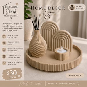 Può includere: Un set decorativo beige composto da un vassoio circolare scanalato, un vaso con texture a spirale e bastoncini neri, due sculture ad arco con dettagli a coste e un piccolo portacandele cilindrico con una candela tea light bianca.