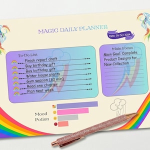 May include: A Magic Daily Planner with a rainbow design and the date 26 Oct 2024. The planner includes a to-do list, main focus section, and mood potion chart. A rose gold glitter pen rests on the planner.