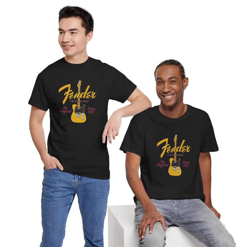 May include: Two people wearing black t-shirts with a Fender Telecaster guitar graphic. The graphic is in yellow and features the word "Fender" in a script font, the guitar image, and the text "The Original Since 1951."