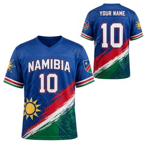 Peut inclure: Un maillot de sport bleu à col en V avec le mot NAMIBIA et le numéro 10 en blanc bordé de rouge. Le motif présente une bande diagonale rouge, blanche et verte, un emblème de soleil jaune et l'inscription YOUR NAME au dos du maillot.