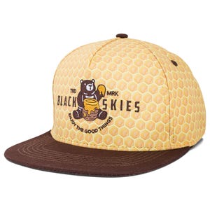 Peut inclure: Casquette de baseball jaune et marron avec un motif en nid d'abeille. La casquette présente un ours tenant un pot de miel, avec le texte "BLACK SKIES" et "ENJOY THE GOOD THINGS".