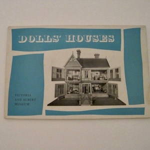 May include: A vintage brochure for the Victoria and Albert Museum's Dolls Houses exhibit. The brochure features a black and white photo of a large dollhouse with multiple levels and windows.