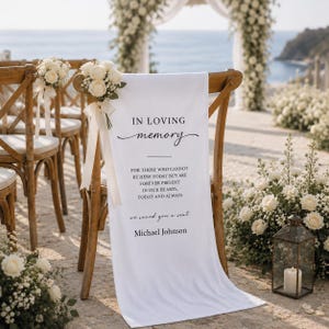 Pode incluir: Uma cadeira de madeira com encosto cruzado coberta com uma placa de tecido branco com o texto em preto: IN LOVING memory, FOR THOSE WHO CANNOT BE HERE TODAY BUT ARE FOREVER PRESENT IN OUR HEARTS, TODAY AND ALWAYS, we saved you a seat, Michael Johnson.