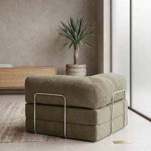 May include: A low-profile modular armchair upholstered in olive green corduroy fabric. The seat features a thick, square-shaped cushion and a backrest, supported by a sleek, silver-toned metal frame that wraps around the exterior sides.