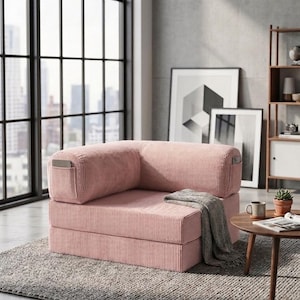 May include: A pink corduroy modular floor chair with a low-profile, rectangular design. The chair features a thick, cushioned seat and backrest with vertical ribbed texture, and includes small side pockets on the outer armrests for storage.