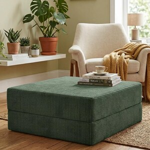 May include: A square, low-profile ottoman upholstered in a dark green corduroy fabric with a distinct ribbed texture. The piece features a clean, boxy silhouette and sits directly on the floor, serving as a versatile seating or footrest option.