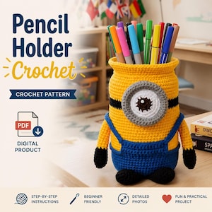 Op de afbeelding: Een gele gehaakte potloodhouder in de vorm van een minion, met blauwe overalls en zwarte accenten. De potloodhouder is gevuld met kleurrijke stiften. Tekst op de afbeelding luidt "Pencil Holder Crochet" en "CROCHET PATTERN".