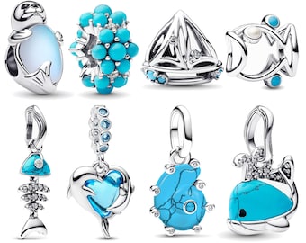May include: A collection of silver charms with ocean-themed designs. Charms include a seal, a cluster of turquoise beads, a sailboat, a fish, a fish skeleton, a dolphin, a turquoise stone, and a whale. Each charm features turquoise or blue accents.