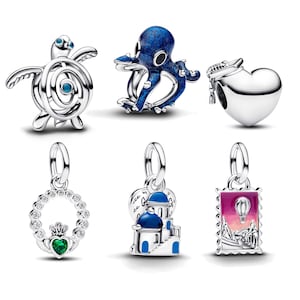 Op de afbeelding: Een verzameling zilveren bedels met verschillende ontwerpen. Inclusief een schildpad, een octopus, een hart met een afstudeerhoed, een Claddagh-ring, een Grieks gebouw en een postzegel met een luchtballon.