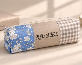 Estuche para lápices personalizado con diseño floral azul y bolsita de algodón con nombre bordado.