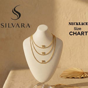 May include: A gold-colored necklace display on a white mannequin. The necklaces are 16, 18, and 20 inches long. The image includes the text "SILVARA" and "NECKLACE Size CHART". The background is a light brown color.