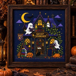 May include: A framed cross-stitch embroidery depicting a two-story building labeled GHOST BOOKSHOP with a crescent moon, bats, and three white ghosts reading books. The scene includes stacks of colorful books, pumpkins, and a black cat.