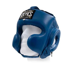 Peut inclure: Casque de boxe bleu avec protection des oreilles et des joues. Le casque est en cuir et porte le logo "REYES" sur le front. Conçu pour protéger la tête pendant la boxe ou d'autres sports de combat.