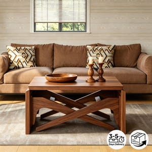 Puede incluir: Una mesa de centro de madera marrón oscuro con una base en forma de X. La mesa está frente a un sofá marrón con cojines estampados. Un cuenco de madera y candelabros están sobre la mesa. La imagen muestra un salón.