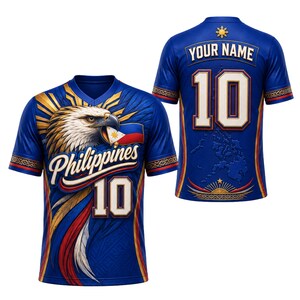 Può includere: Una maglia blu con la grafica di un'aquila che tiene la bandiera filippina, la parola Philippines e il numero 10 sul davanti. Il retro mostra il testo YOUR NAME, il numero 10, un emblema solare e una mappa delle isole filippine.