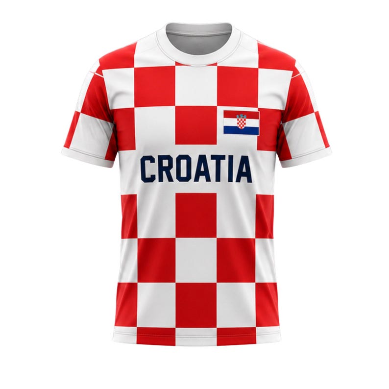Może przedstawiać: Biała koszulka z czerwono-białym wzorem w kratę, z napisem "CROATIA" w granatowych literach. Chorwacka flaga jest wyświetlana w prawym g&oacute;rnym rogu klatki piersiowej. Koszulka ma kr&oacute;tkie rękawy i okrągły dekolt.
