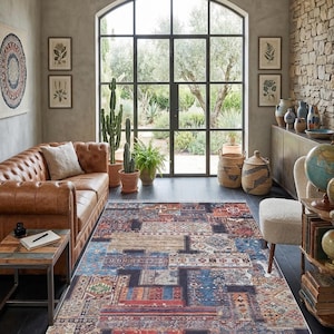 May include: A colorful patchwork rug with a distressed, vintage look. The rug features a mix of geometric and floral patterns in shades of blue, red, beige, and brown. It has a fringed edge and is placed in a living room setting.